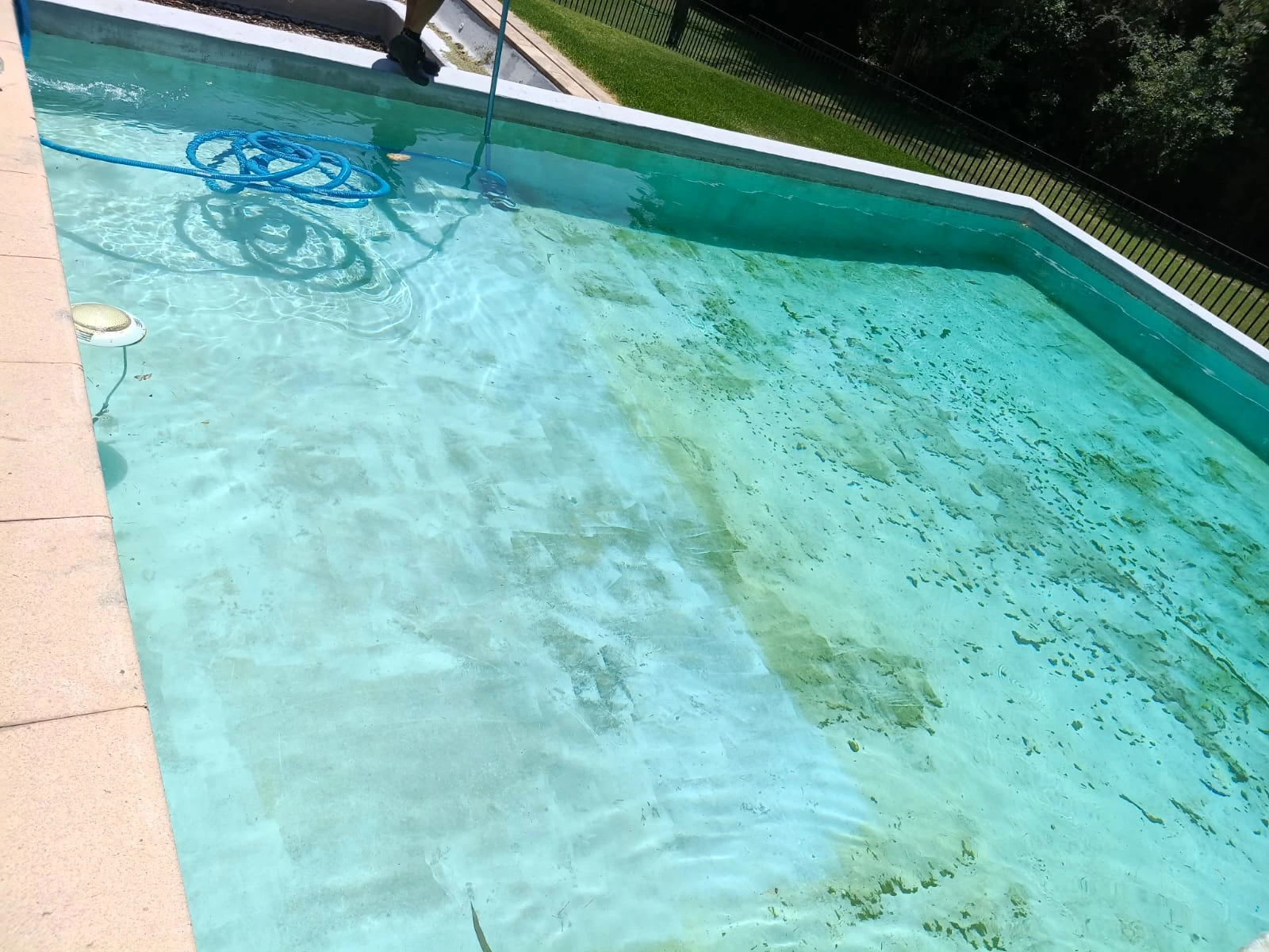 Limpieza del fondo de una piscina con el agua todavía turbia