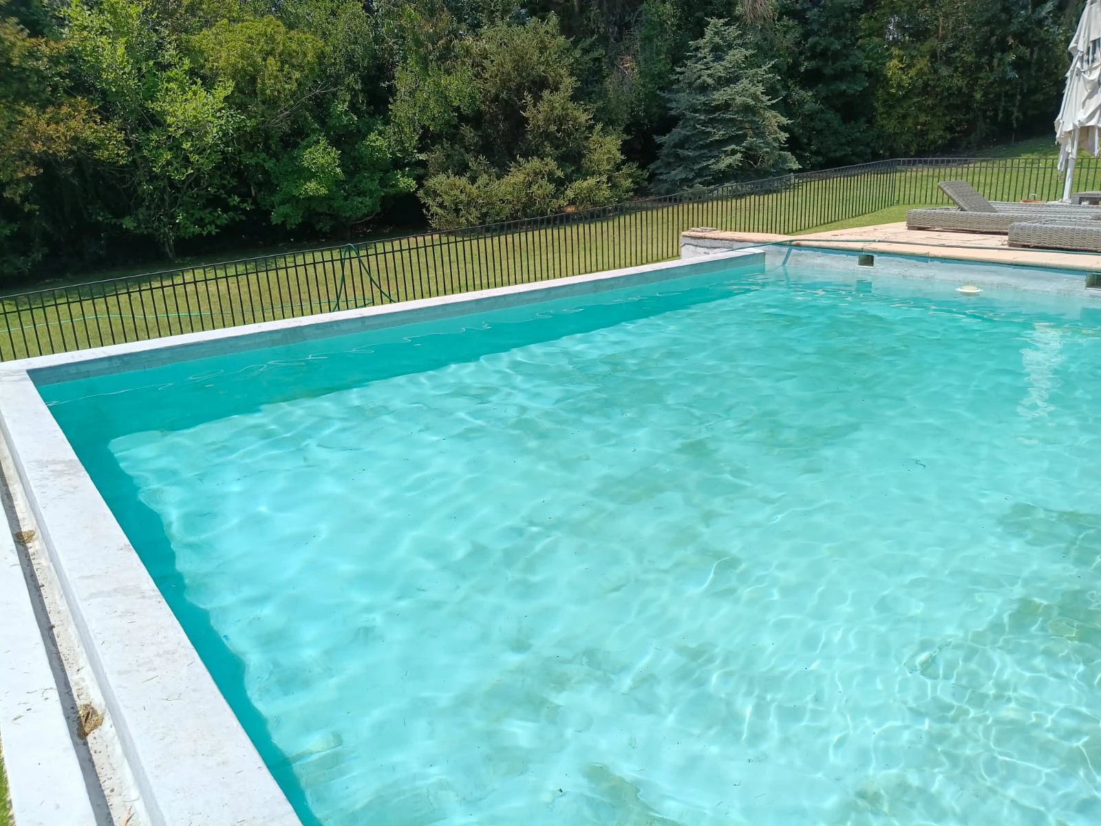 La misma piscina con el agua turquesa y el fondo limpio