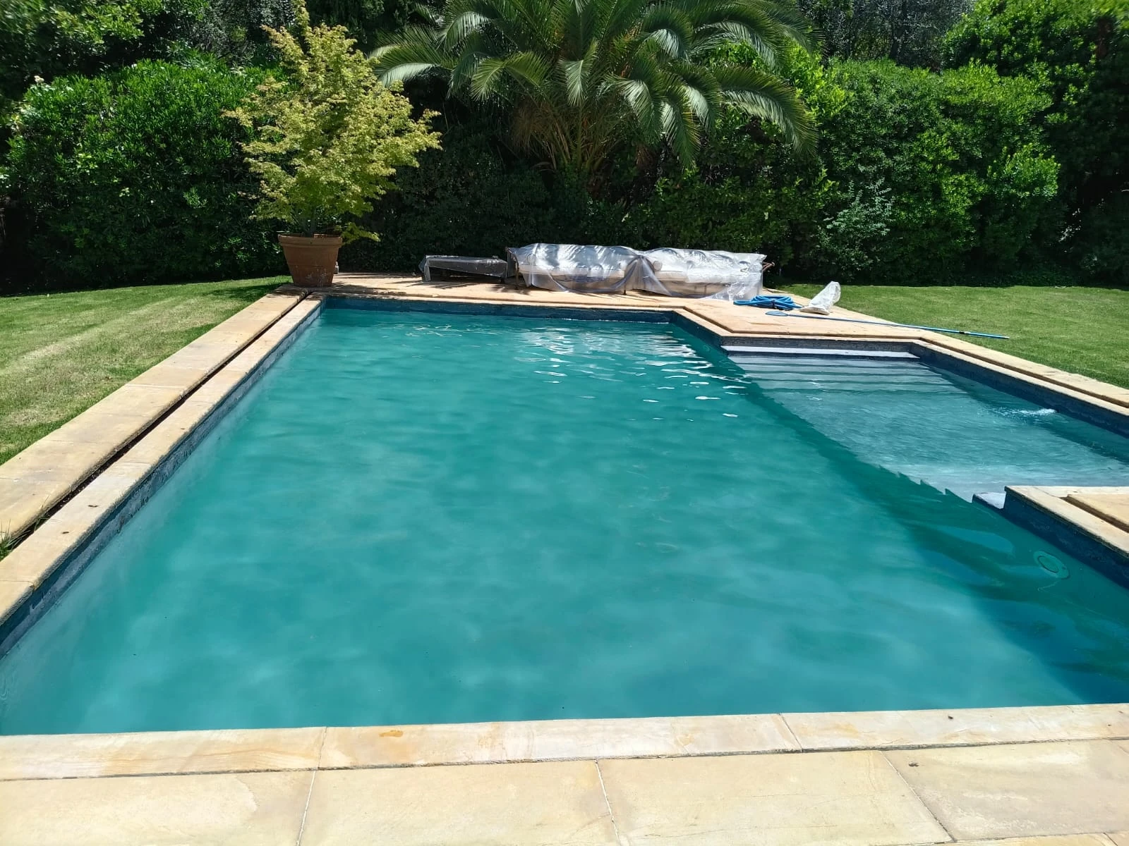 La misma piscina con el agua cristalina tras el tratamiento