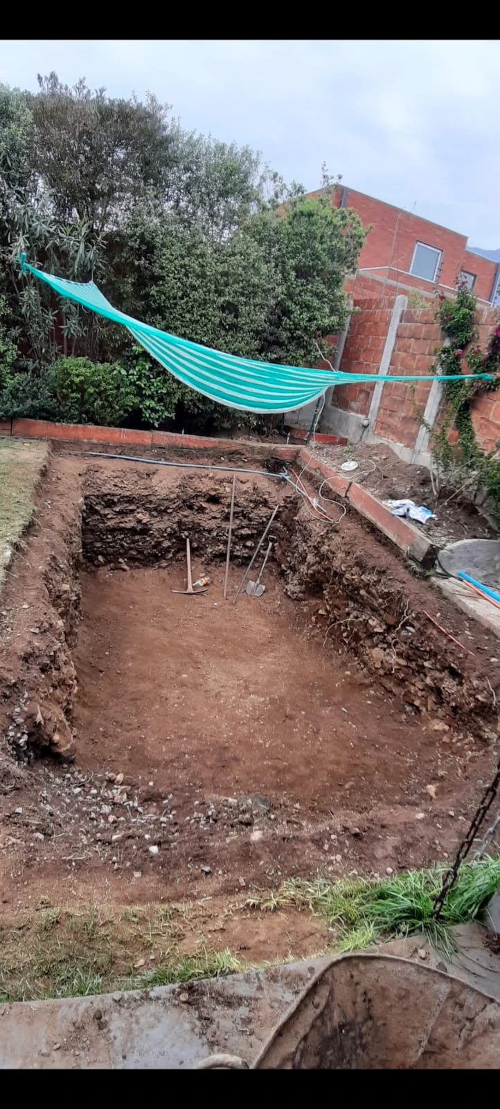 Excavación rectangular terminada en el patio de una casa